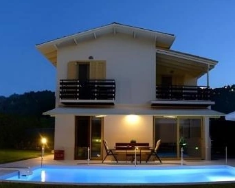 Modern villa in Agios Ioannis Lefkada with private pool illuminated at sunset